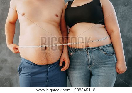 Overweight Couple Standing Together Wrapped With Measure Tape. Dieting, Family Weight Losing And Hea