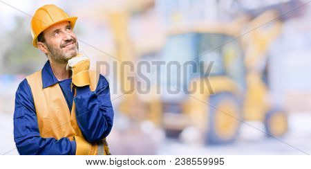 Senior engineer man, construction worker thinking and looking up expressing doubt and wonder at work