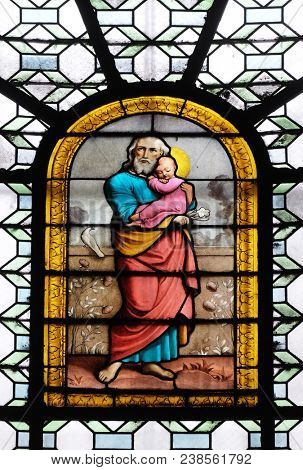 PARIS, FRANCE - JANUARY 04: Saint Joseph holding child Jesus, stained glass window in the Saint Sulpice Church, Paris, France on January 04, 2018.