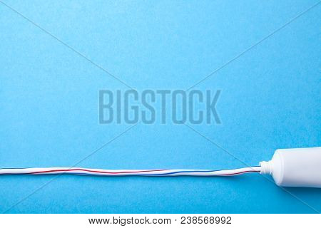 Colored Toothpaste Squeezed Out Line From Tube On Blue Background