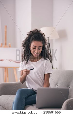 Online Purchase. Nice Positive Woman Sitting In Front Of The Laptop While Buying Things Online