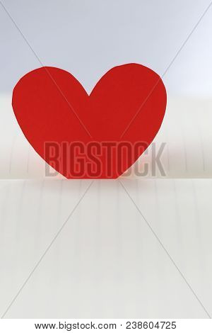 Heart Red Paper Plugged On The White Book Floor And Have Copy Space For Design In Love Concept.