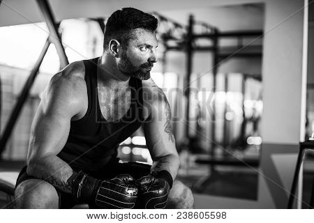 Tired Male Boxer Sitting On Stool In Gym