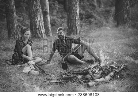 New Technology Or Archaism Concept. Couple Of Hikers Relax At Bonfire In Forest. Man Hipster Smile W