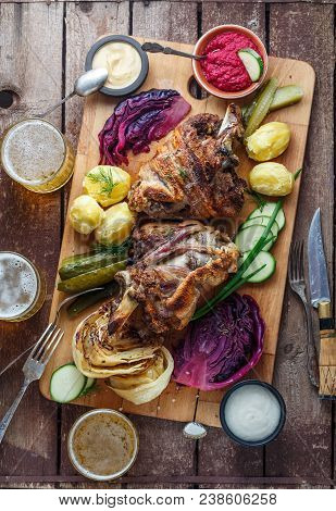 Roasted Pork Knuckle Eisbein With Braised Boiled Cabbage, Potato, Pickles, Dip And Beer, Top View.