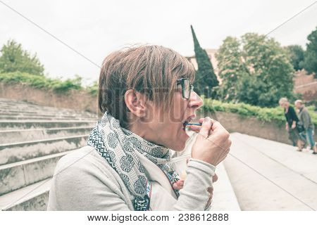 Traveling Woman Eating Voraciously Ice Cream Outdoors. Toned Image, Vintage Style.