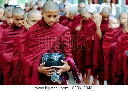 Myanmar, Amarapura - June 28, 2015: Buddhist Monks Queue For Lunch In Front Of Mahagandayon Monaster