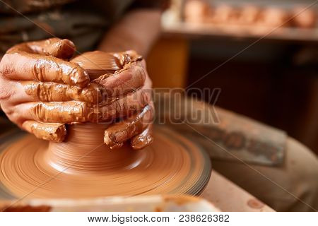Close-up Hands Of A Male Potter In Plaid Shirt And Dirty Apron Who Molds A Vase From Clay, Selective