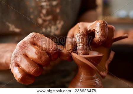 Close-up Hands Of A Male Potter In Plaid Shirt And Dirty Apron Who Molds A Vase From Clay, Selective