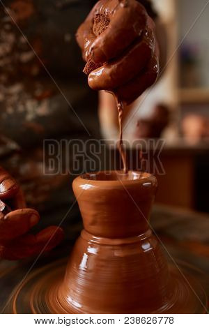 Close-up Hands Of A Male Potter In Plaid Shirt And Dirty Apron Who Molds A Vase From Clay, Selective