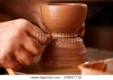 Close-up Hands Of A Male Potter In Plaid Shirt And Dirty Apron Who Molds Bowl From Clay, Selective F
