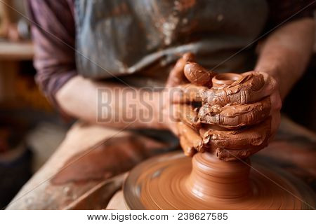 Close-up Hands Of A Male Potter In Plaid Shirt And Dirty Apron Who Molds Bowl From Clay, Selective F