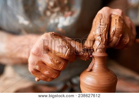 Close-up Hands Of A Male Potter In Plaid Shirt And Dirty Apron Who Molds Bowl From Clay, Selective F