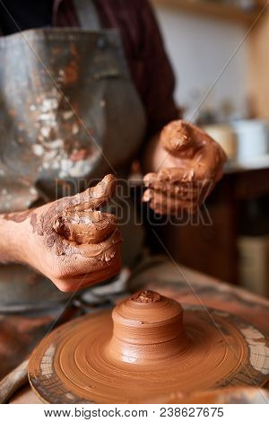 Close-up Hands Of A Male Potter In Plaid Shirt And Dirty Apron Who Molds Bowl From Clay, Selective F