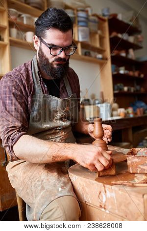 Portrait Of A Handsome Bearded Male Potter In Plaid Shirt And Dirty Apron Who Molds Bowl From Clay, 