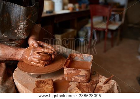 Close-up Hands Of A Male Potter In Plaid Shirt And Dirty Apron Who Molds Bowl From Clay, Selective F