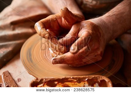 Close-up Hands Of A Male Potter In Plaid Shirt And Dirty Apron Who Molds Bowl From Clay, Selective F