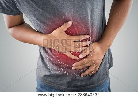 The Photo Of Large Intestine Is On The Man's Body Against Gray Background, People With Stomach Ache 