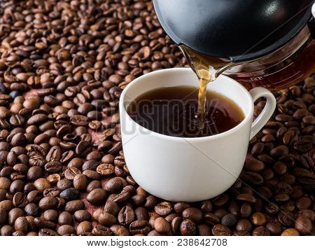 Cup And Pot Of Coffee On Coffee Beans Background