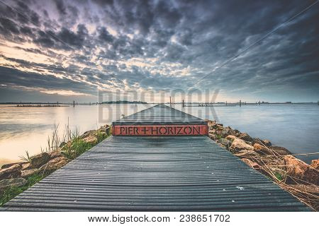 Landart In The Netherlands. Vista With Water, Jetty And Nature Under A Beautiful Cloudy Sky With Sun