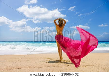 Woman walking on the wild beach of the island of Lefkada in Greece 
