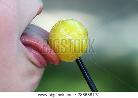 A Kid Tonque Eating The Candy, Photo