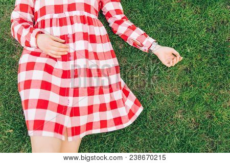 Woman Lay On Green Grass In Red Dress. Overhead View