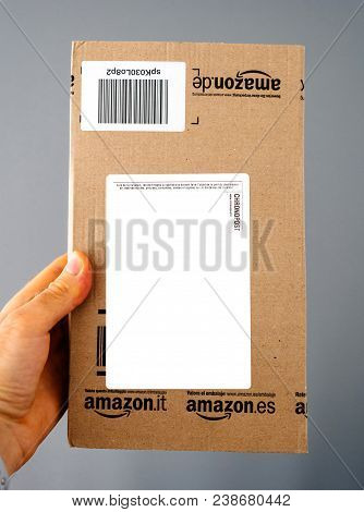 Paris, France - Apr 24, 2018: Man Holding The Front View With White Sticker Of Amazon Prime Cardboar