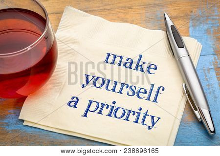 Make yourself a priority advice - handwriting on a napkin with a cup of tea