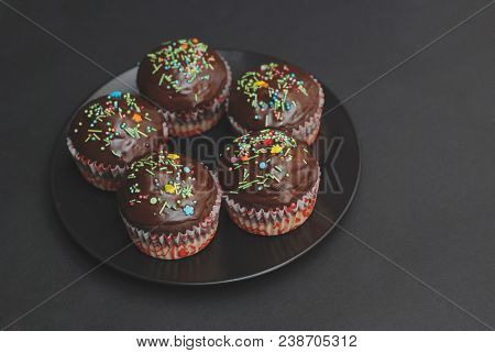 Homebaked Chocolate Muffins For Easter With Colored Conffeti. Dark Background. Sweet Dessert
