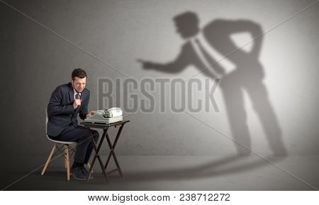 Little man working and a big shadow arguing with him