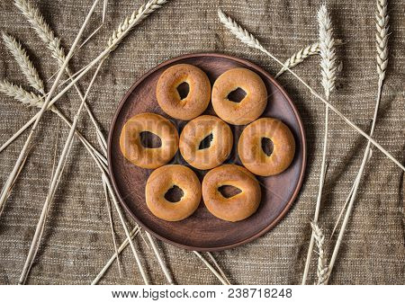 A Bagels In A Plate With Spikelets On Sackcloth Background