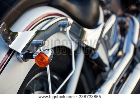 Close up view of a shiny chrome motorcycle design engine with blinker.