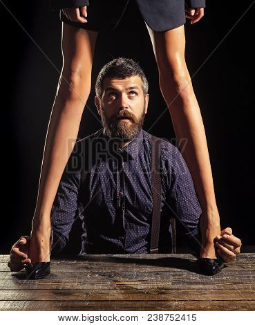Businessman At Table With Female Legs. Love And Relations, Dominating. Legs Of Woman In Shoes At Man