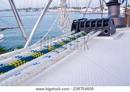 Sailboat Detailed Parts. Close Up On Winch And Rope Of Yacht Over Blue Sea. Yachting Concept. Shallo