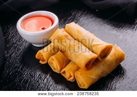 Lumpias With Sweet Sauce On A Black Background