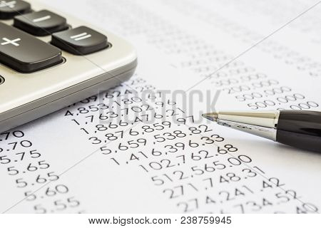 Closeup Of Financial Statements, Annual Reports With Modern Pen And Calculator In Flame, Black And W