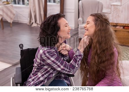 Family Day. Optimistic Handicapped Woman And Girl Holding Hands While Nickering