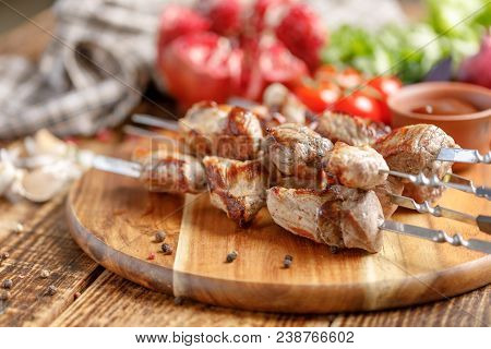 Appetizing Shish Kebab From Pork And Ripe Pomegranate Close-up. Juicy Meat Cooked On An Open Fire. R