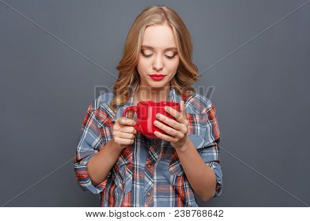 Serious Girl Is Holding Big And Red Cup And Looking At It. She Is Very Concentrated. Isolated On Gre