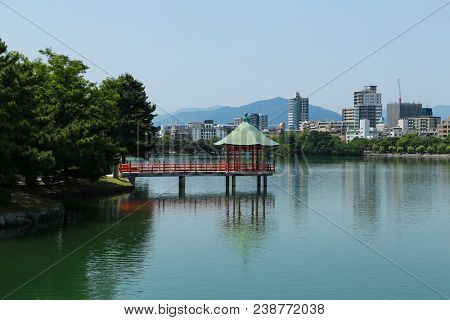 Red Pagoda With Green Roof Surround By Water In Ohori Park, Fukuoka, Japan