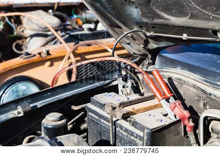 Jump Starting A Old Car Battery With Another Vehicle And Jumper Leads Outdoor