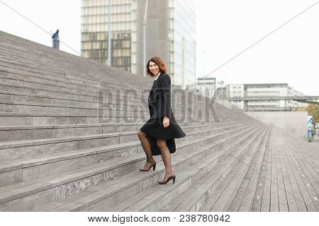 American Businesswoman Going Up On Stairs In High Buildings Background. Concept Of Career And Busine
