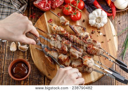 Rustic Still Life. Juicy Pork Meat Is Cut With A Knife And Fork. Appetizing Shish Kebabs And Fresh V