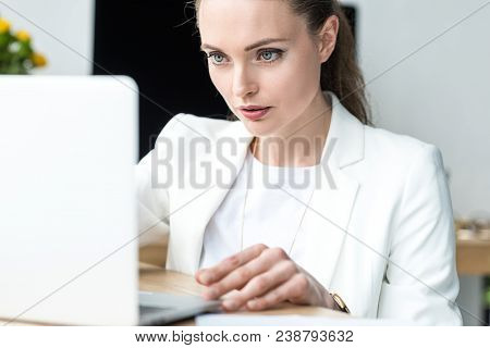 Selective Focus Of Focused Businesswoman Working On Laptop At Workplace In Office