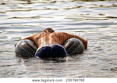 A Man Rests On A Rubber Circle On The Water, In Relaxation He Merged With Nature.