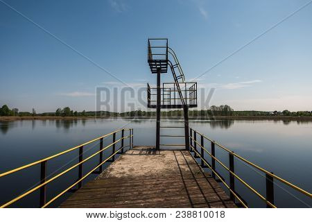 Silhouette Of Diving Tower On The Lake In Summer Evening