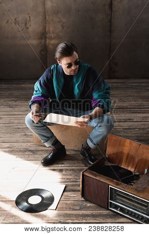Handsome Young Man In Vintage Windcheater With Vinyl Record Player