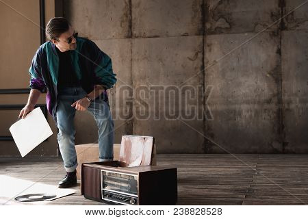 Stylish Young Man In Vintage Windcheater With Vinyl Record Player