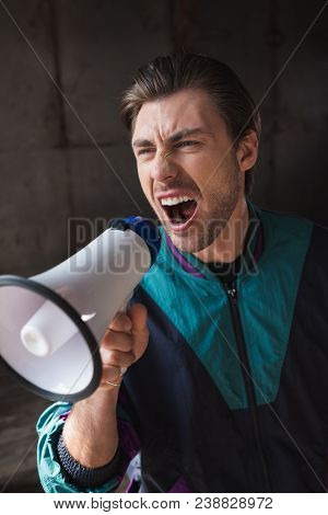 Angry Young Man In Vintage Windcheater Shouting With Loudspeaker
